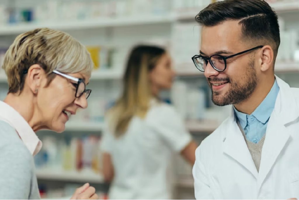 Portrait of a male pharmacist helping a patient in a pharmacy